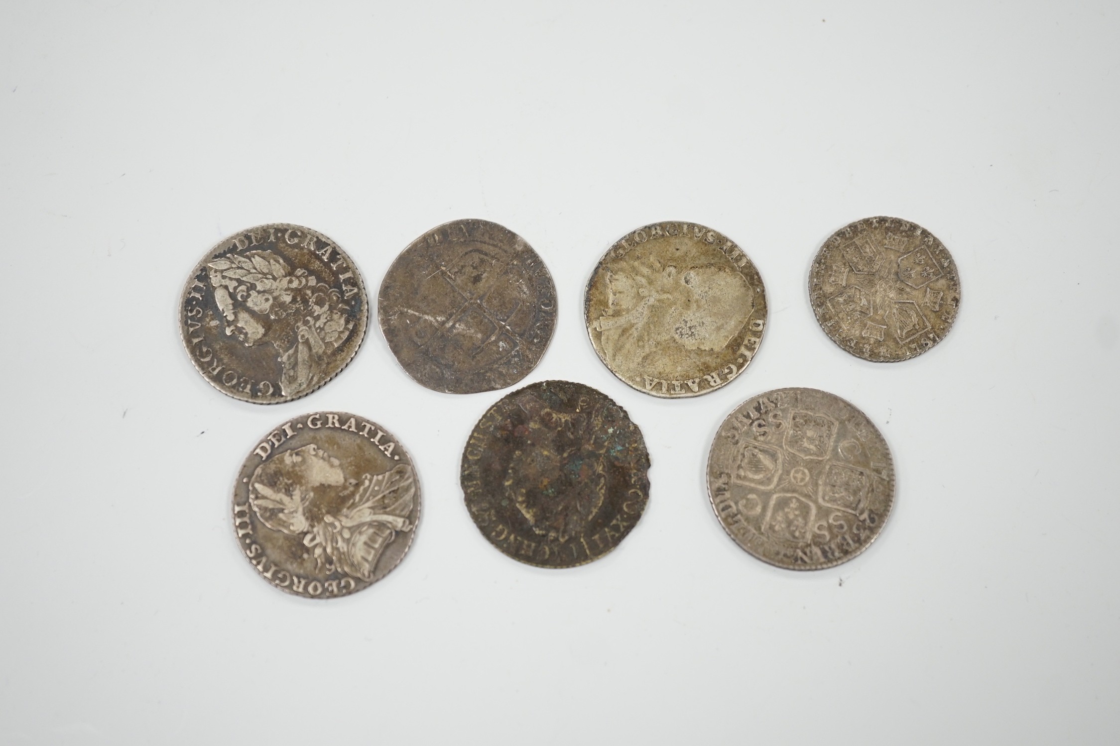 Four 18th century shillings, a sixpence an Elizabeth I coin and a token